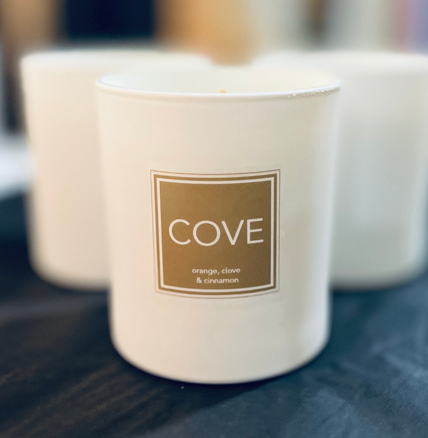 Candle with 'Cove' label on a blurred background