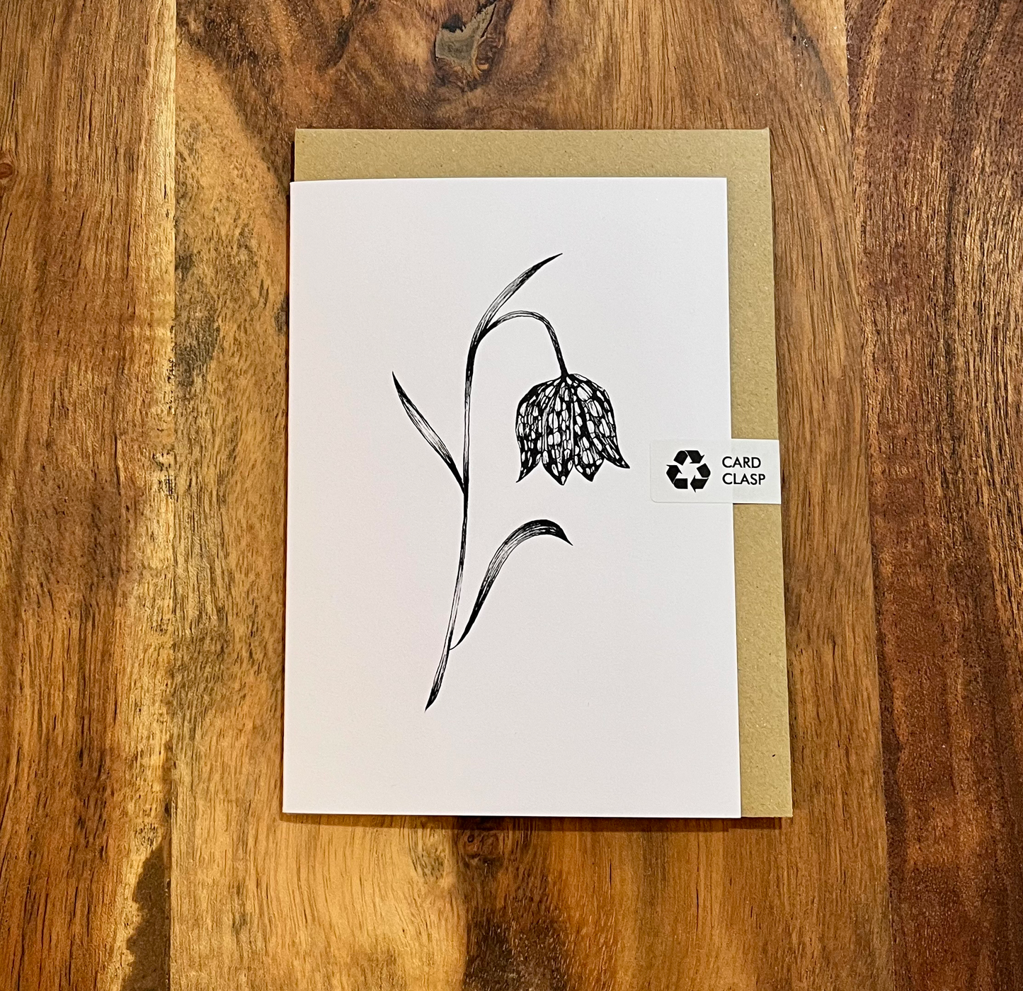 Greeting card with floral design on a wooden surface