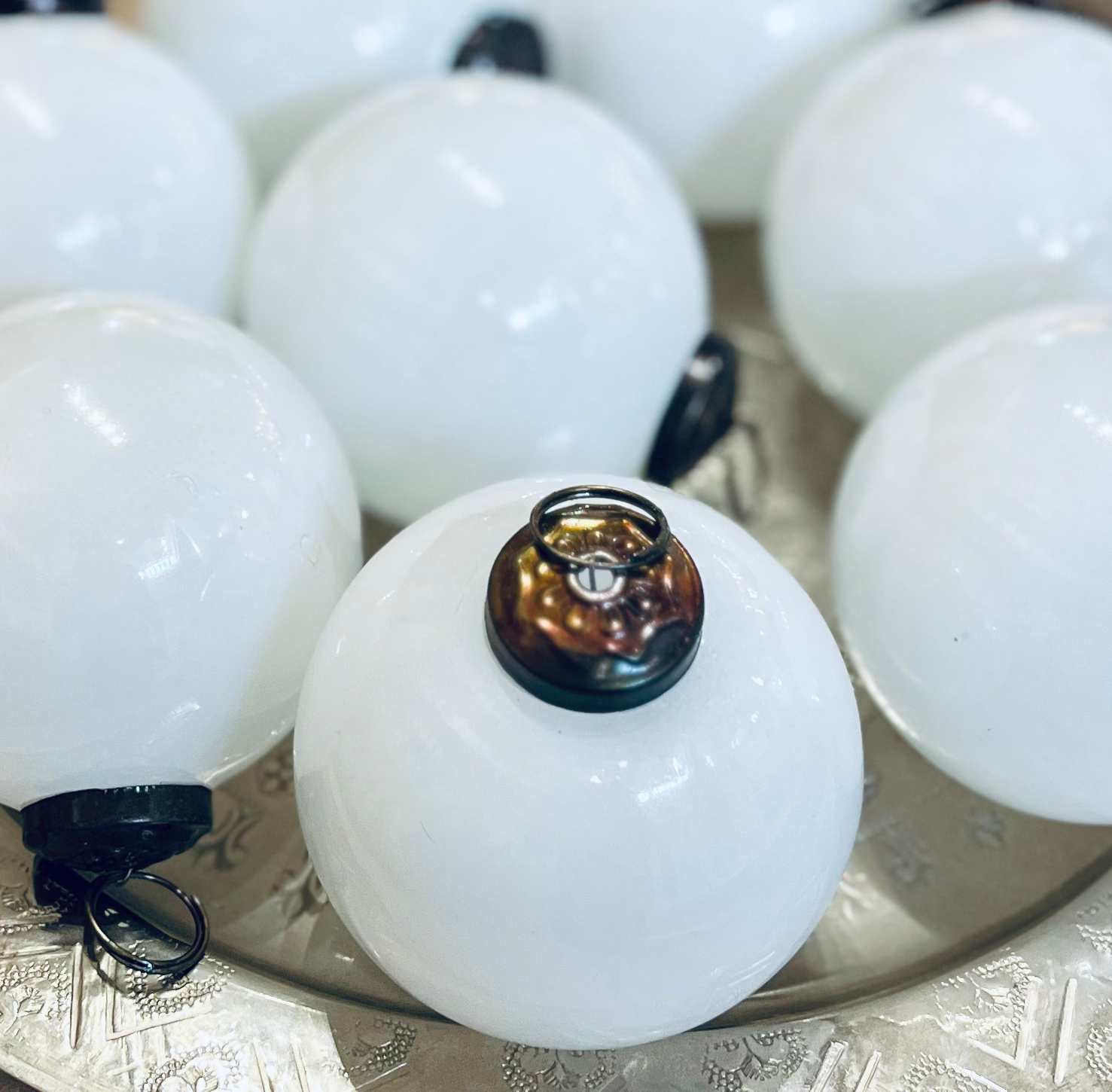 Close-up of white spherical objects with metallic caps on a textured surface