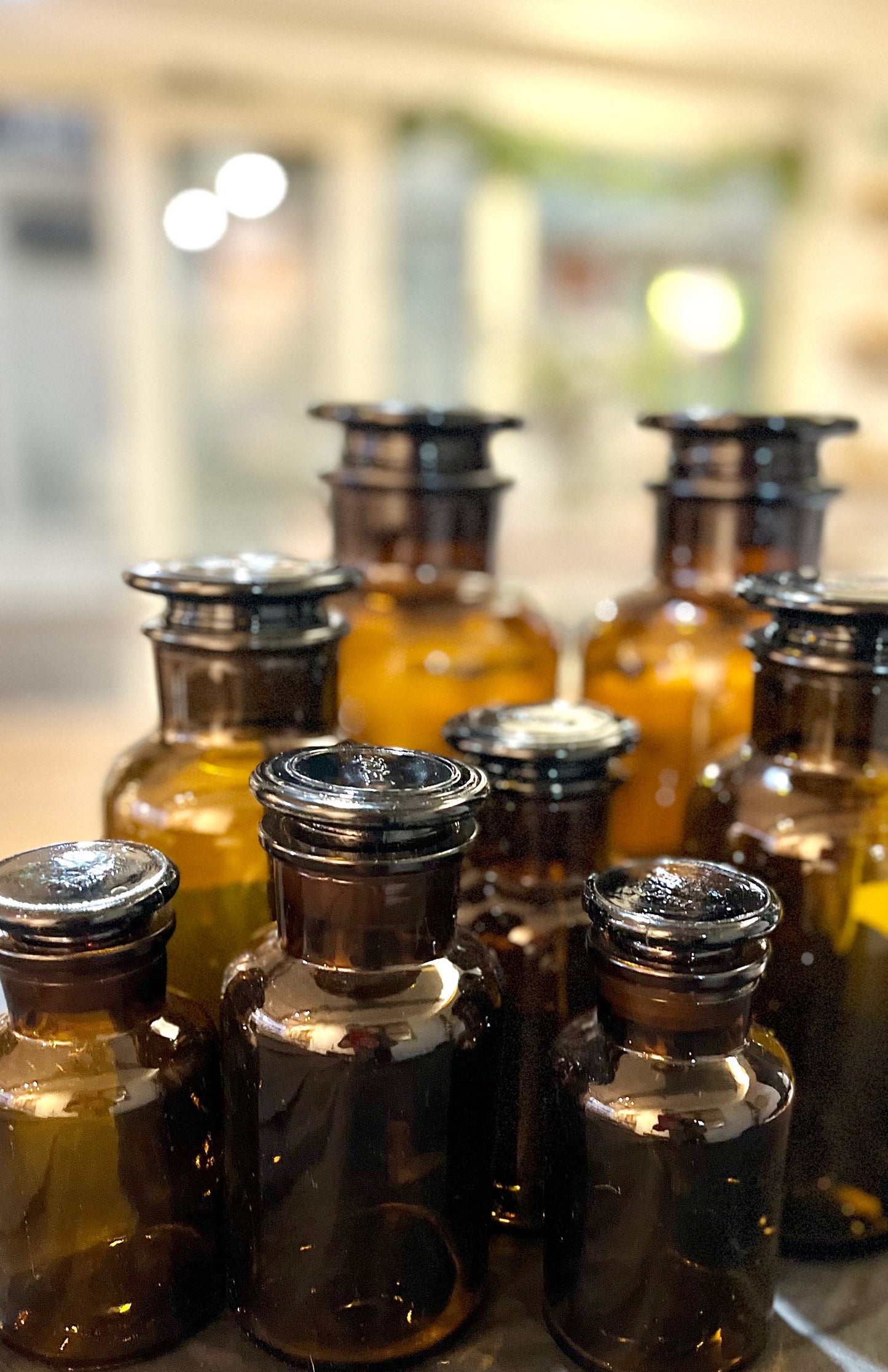 Collection of glass Apothecary Bottle Storage Jars with metal caps on a blurred background