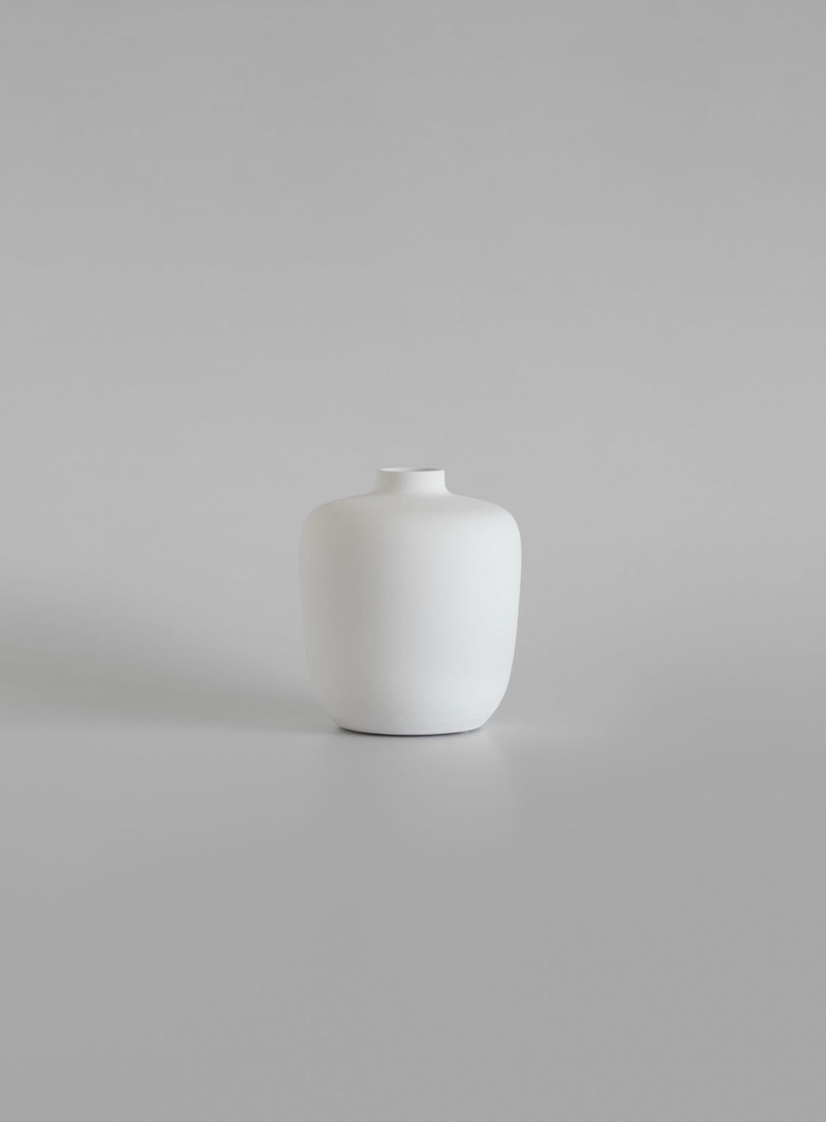 White ceramic vase on a light gray background