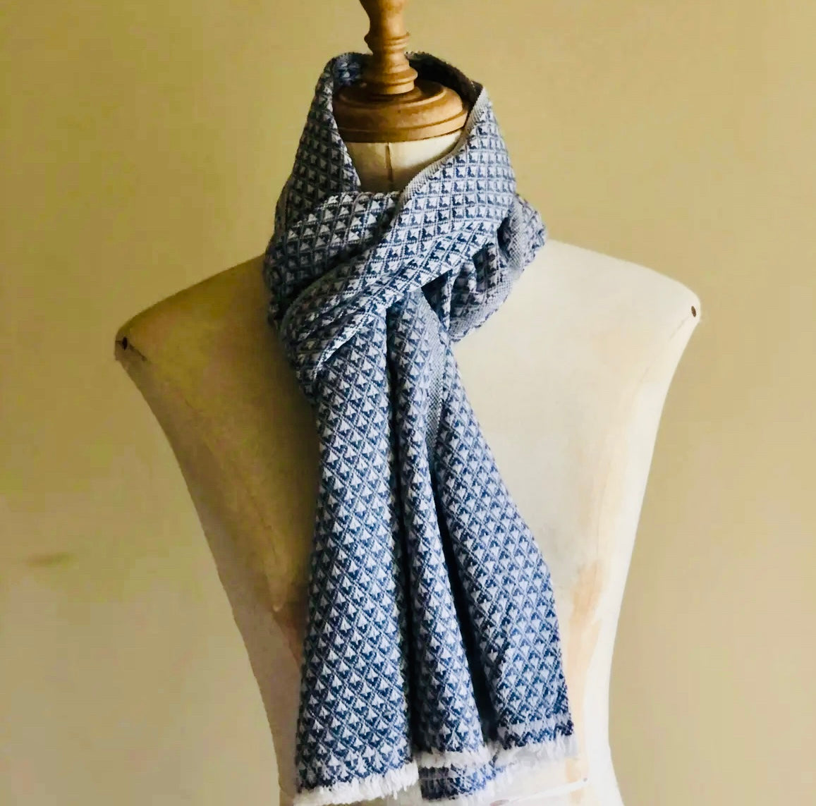 Blue patterned scarf on a mannequin against a beige background