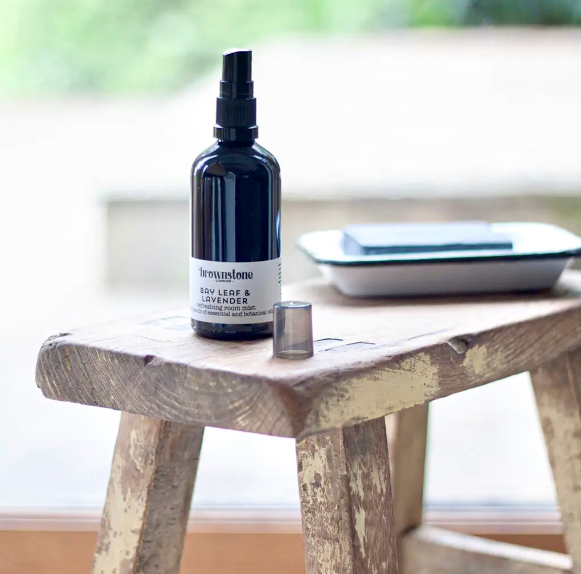 Bottle of 'Farmhouse' mist on a wooden stool with a blurred background
