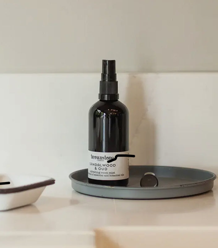 Black spray bottle labeled 'Breathe' on a gray tray with a neutral background