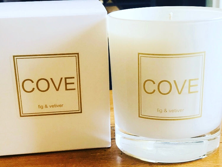 Cove candle and packaging on a wooden surface