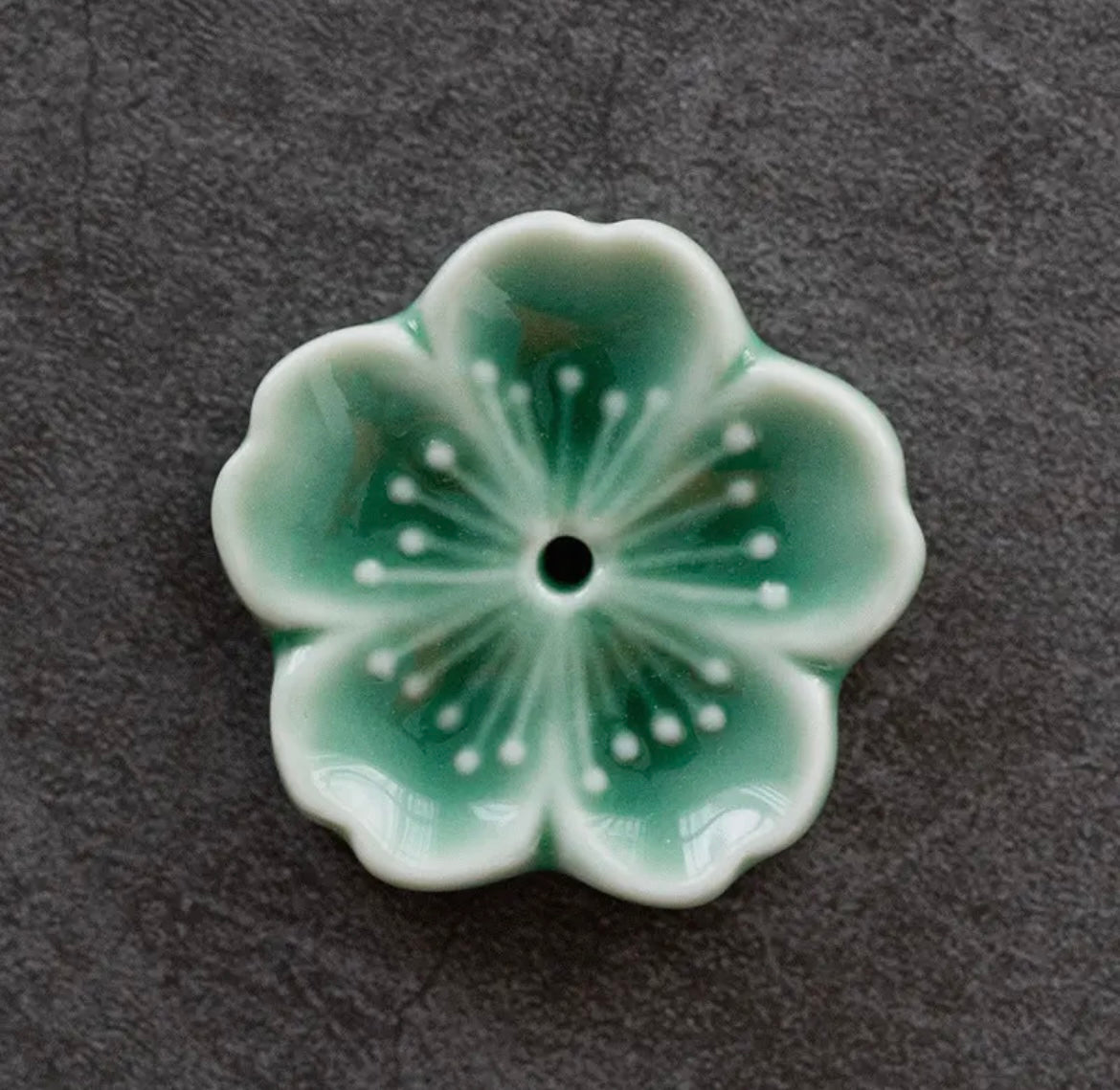 Green ceramic flower on a dark gray background