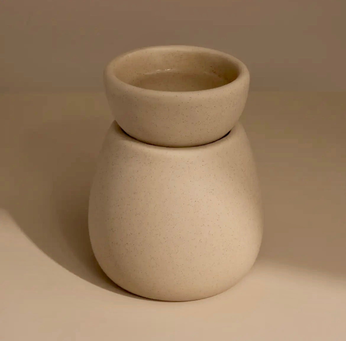 Beige ceramic vase with a smooth texture on a beige background