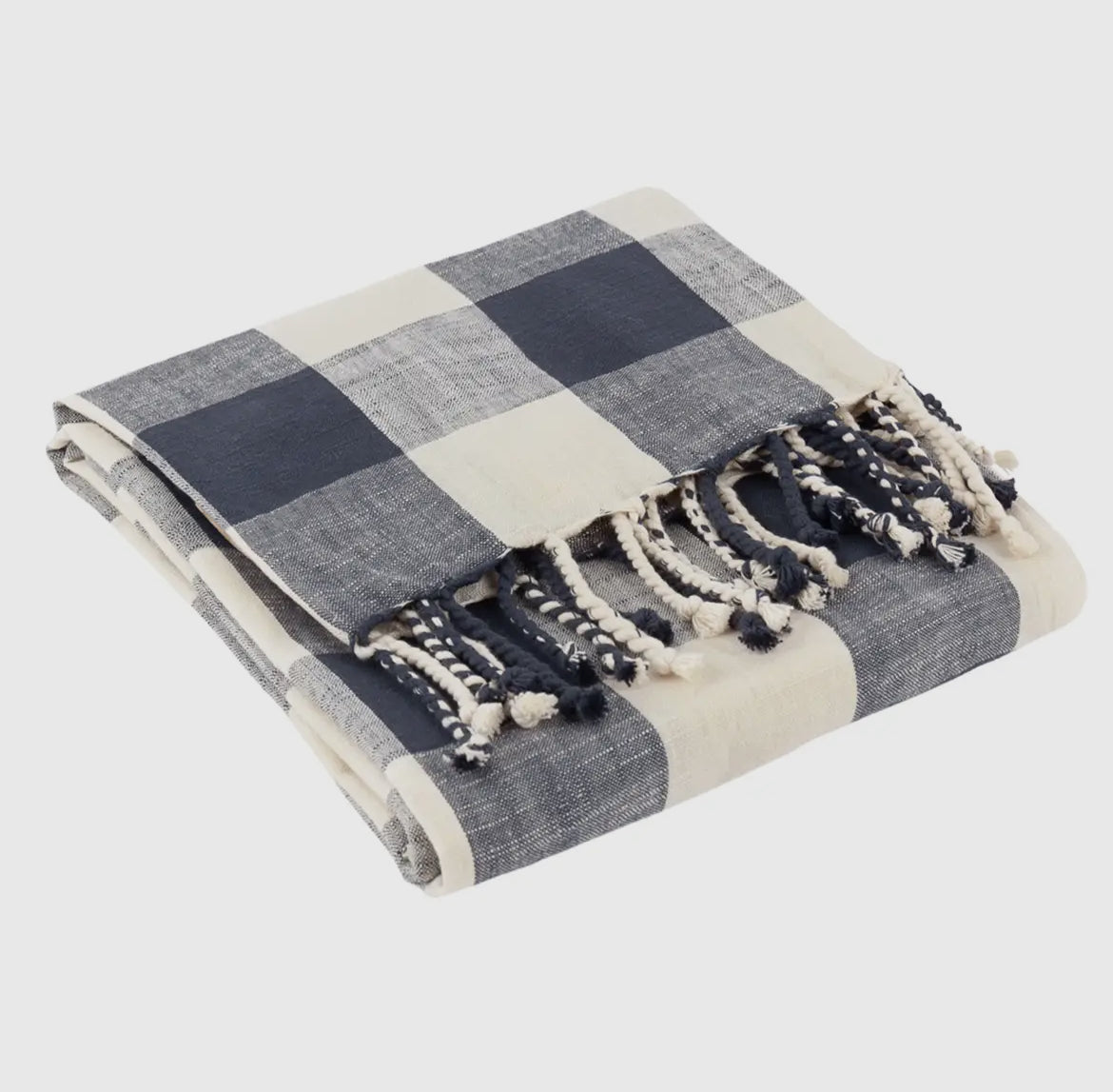 Blue and white checkered throw blanket with tassels on a light gray background