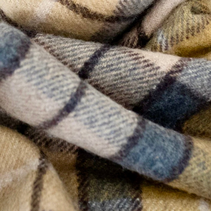 Close-up of plaid fabric with brown, blue, and beige colors.