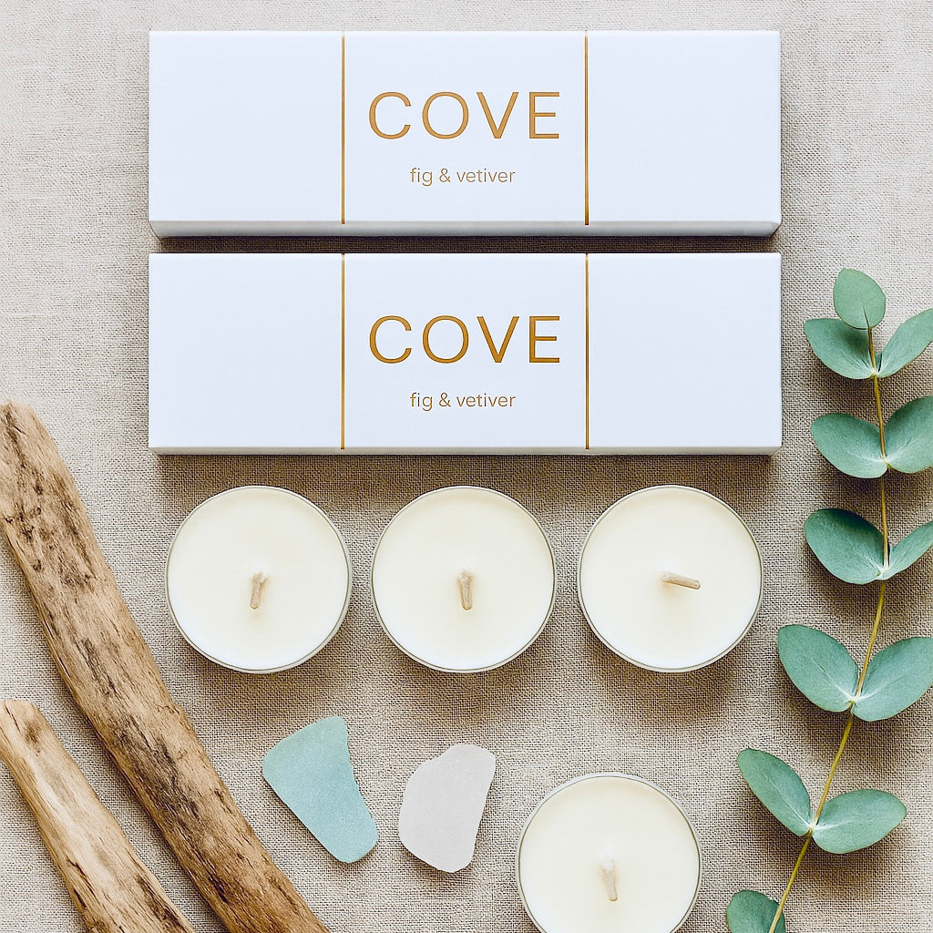 Cove candles with packaging on a textured surface with natural elements.