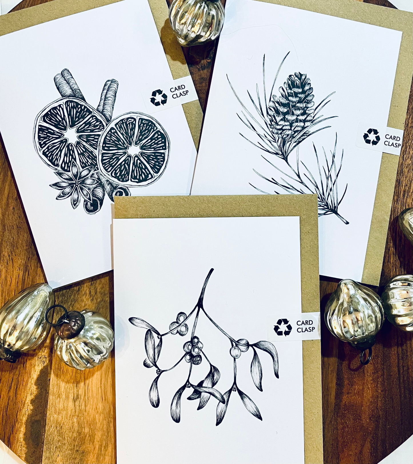 Set of greeting cards with black and white illustrations on a wooden surface.