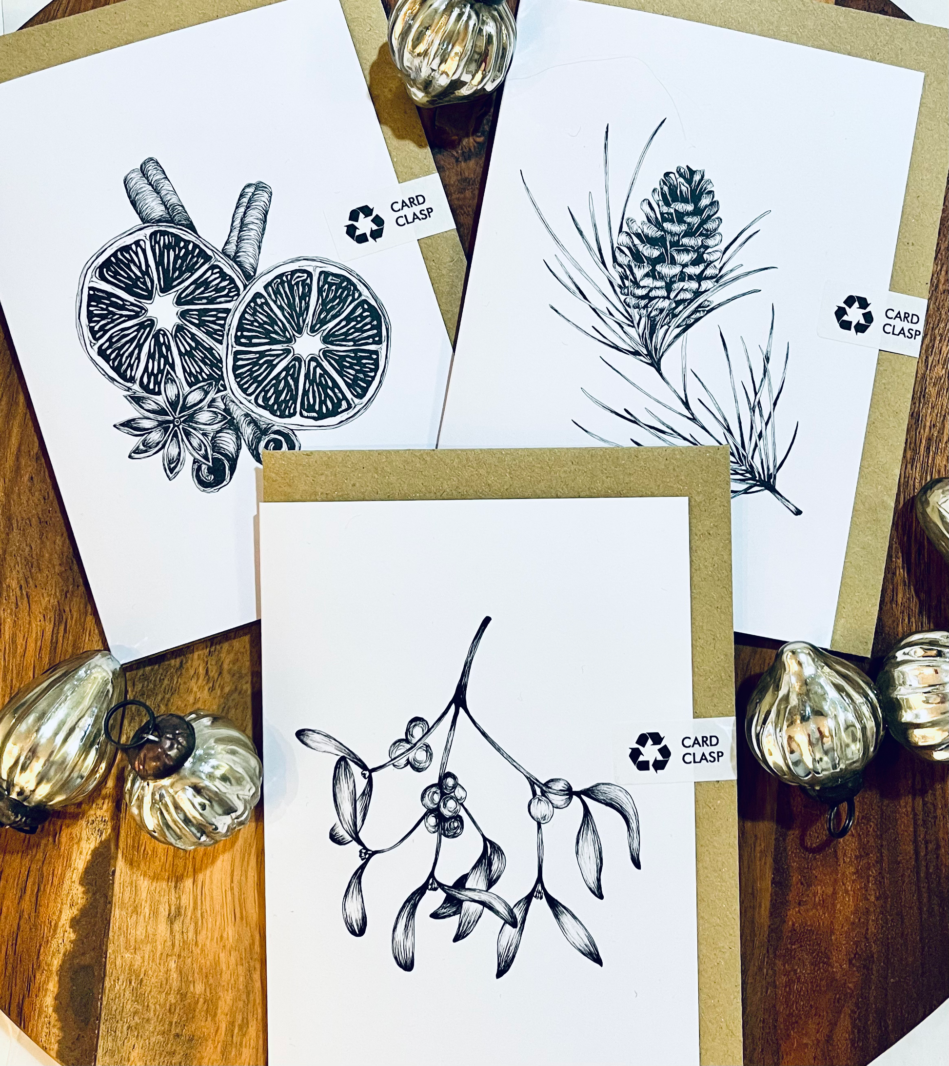 Set of greeting cards with black and white illustrations on a wooden surface.