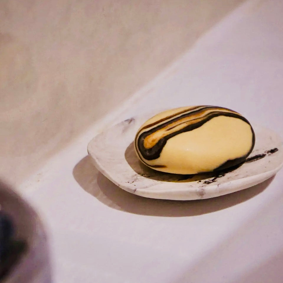 Marbled soap bar on a white marble soap dish