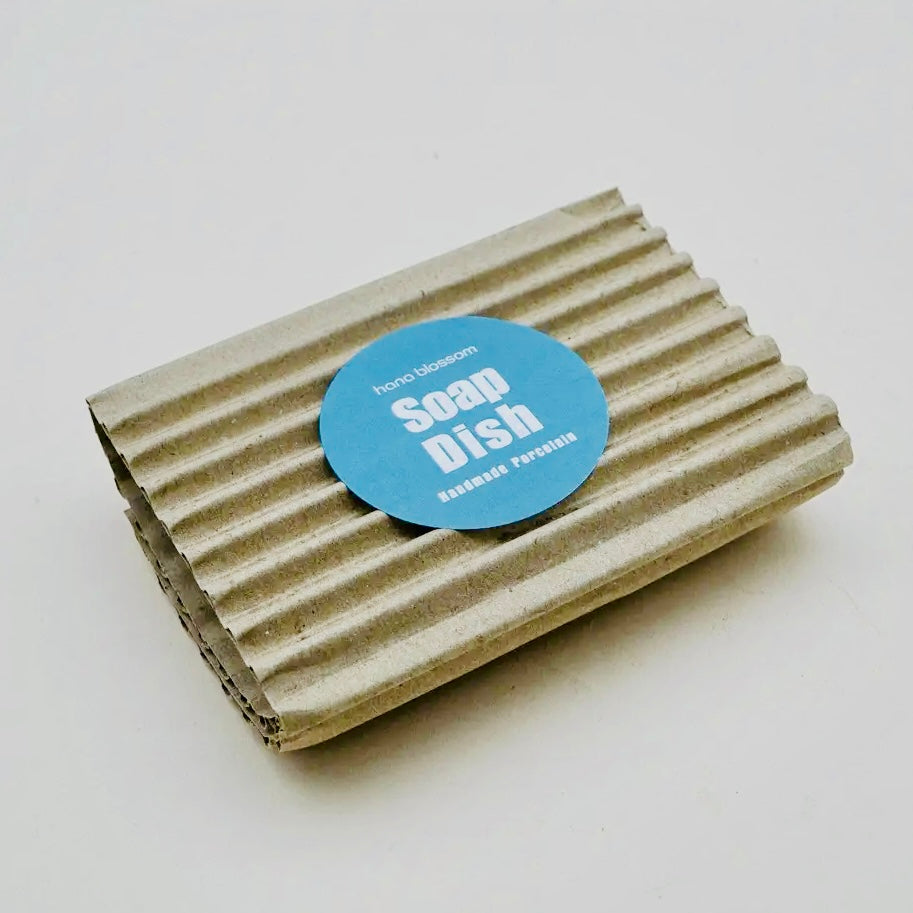 Cardboard soap dish with a blue label on a white background