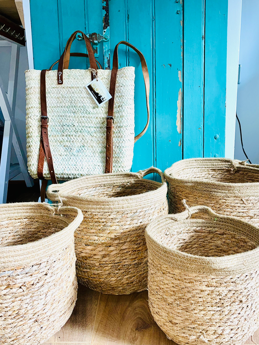 Woven Jute & Straw Baskets and a bag against a blue wooden door