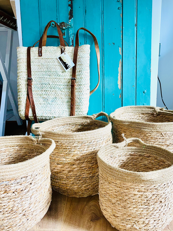 Woven Jute & Straw Baskets and a bag against a blue wooden door