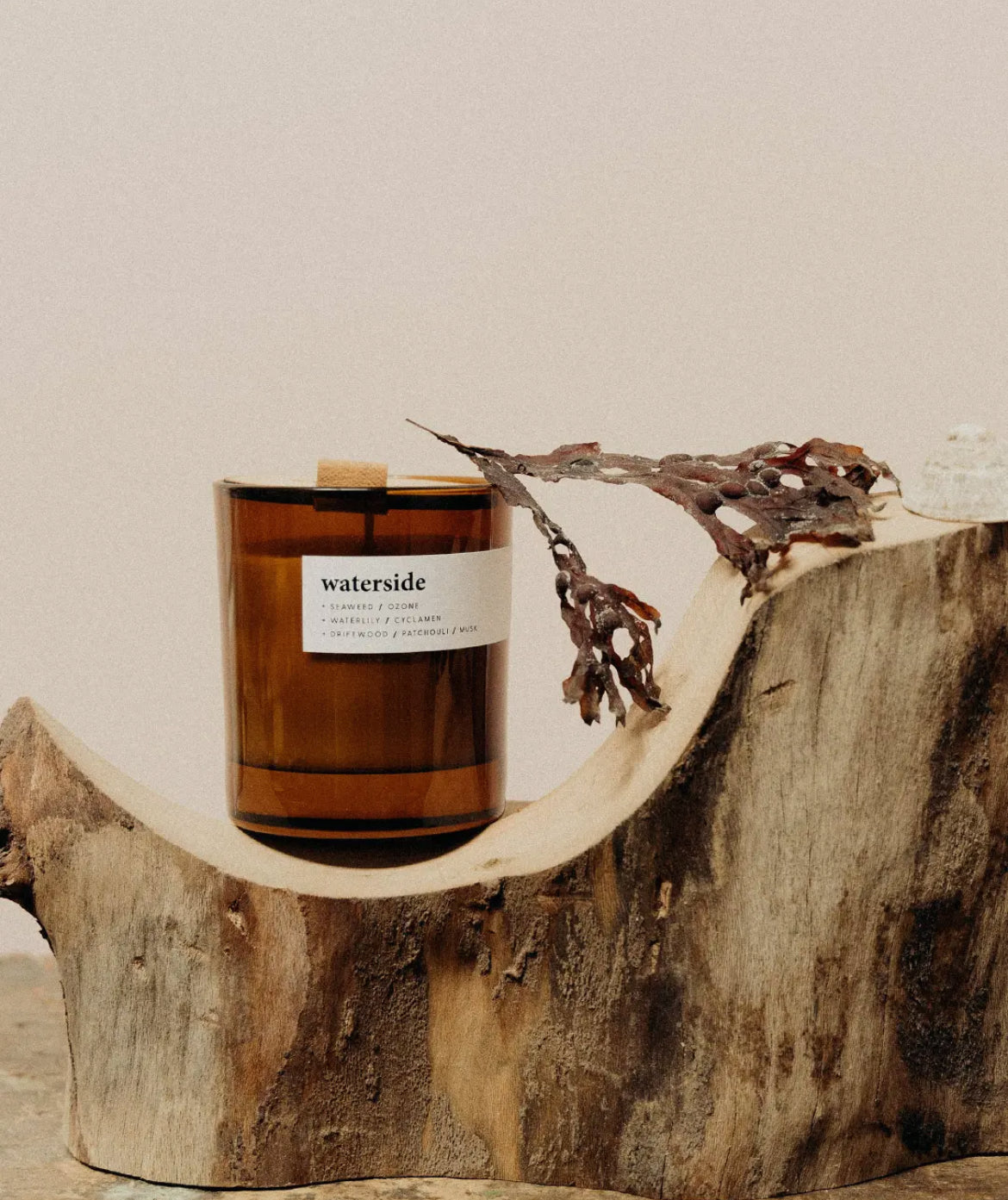 Candle labeled 'waterside' on a wooden surface with a neutral background