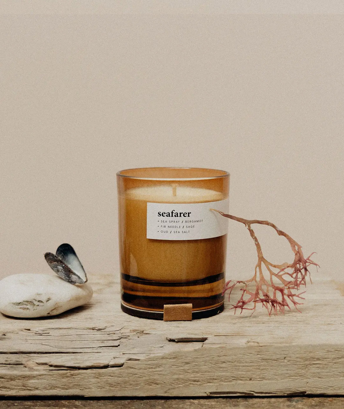 Candle labeled 'seafarer' on a wooden surface with natural elements