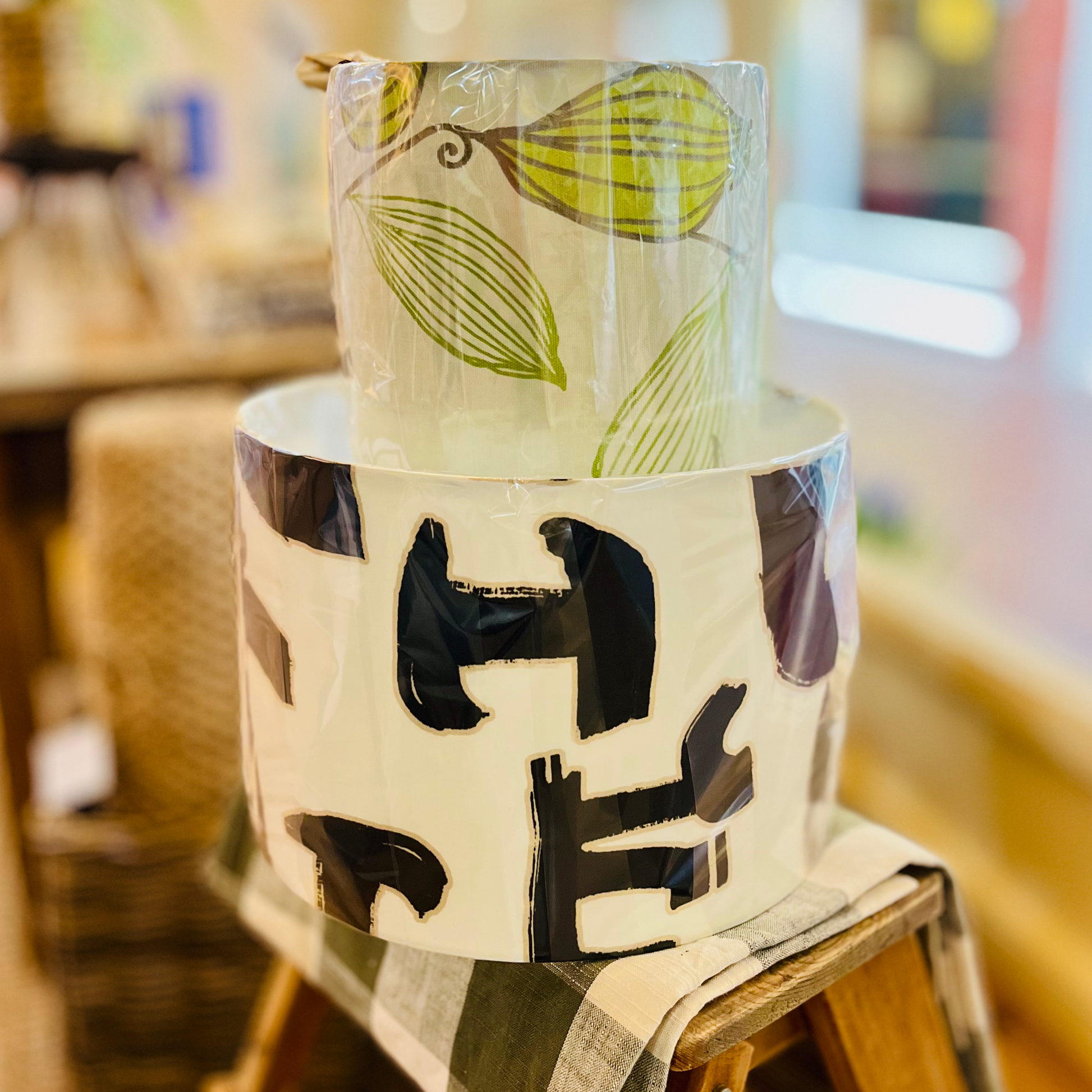 Lampshade with leaf and abstract design on a wooden stool