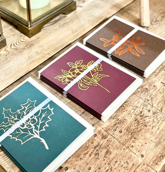 Set of Luxury Christmas Cards with leaf designs on a wooden surface