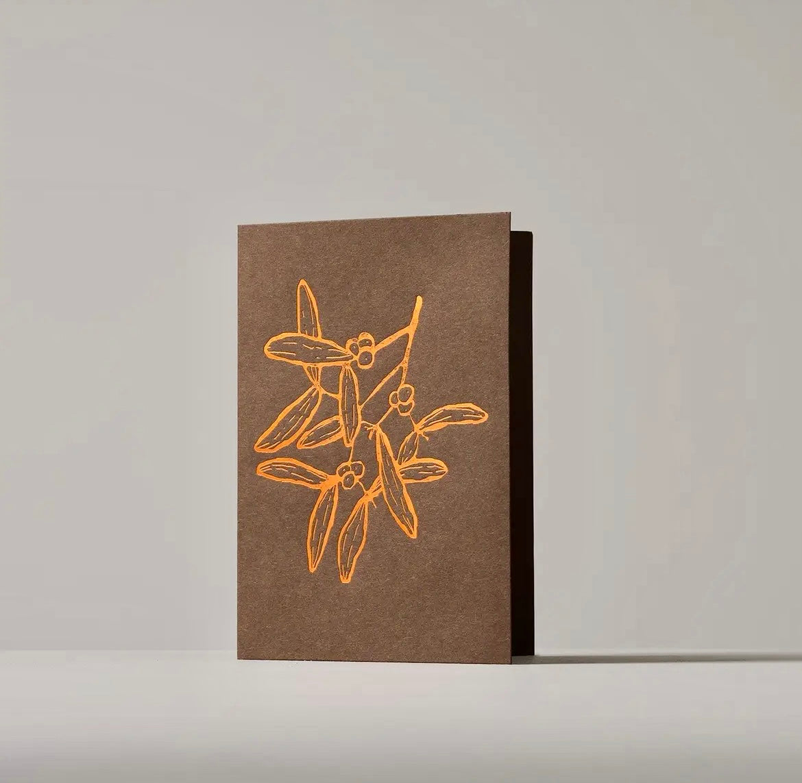 Brown card with gold floral design on a gray background