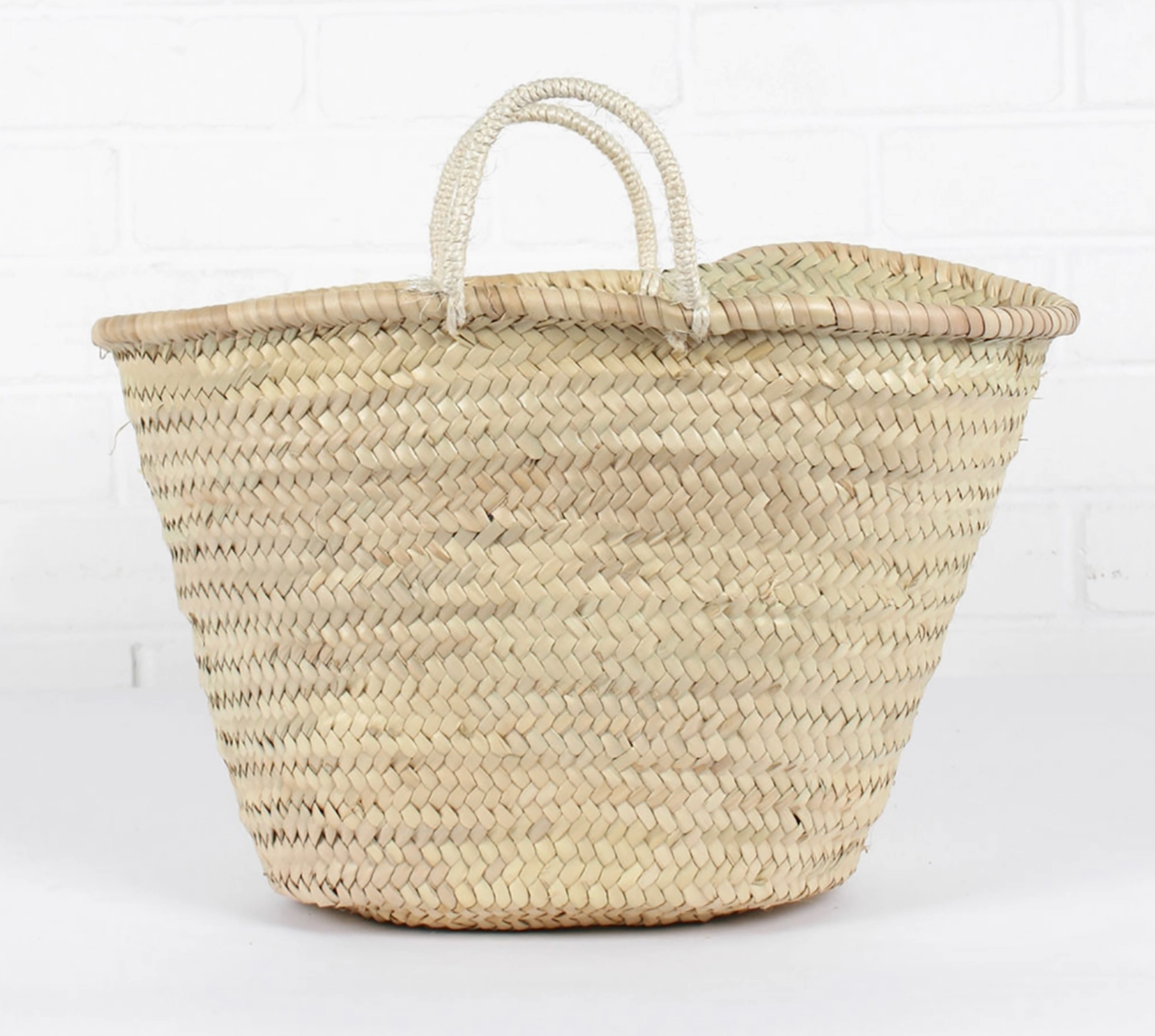 Woven basket with handles on a white background