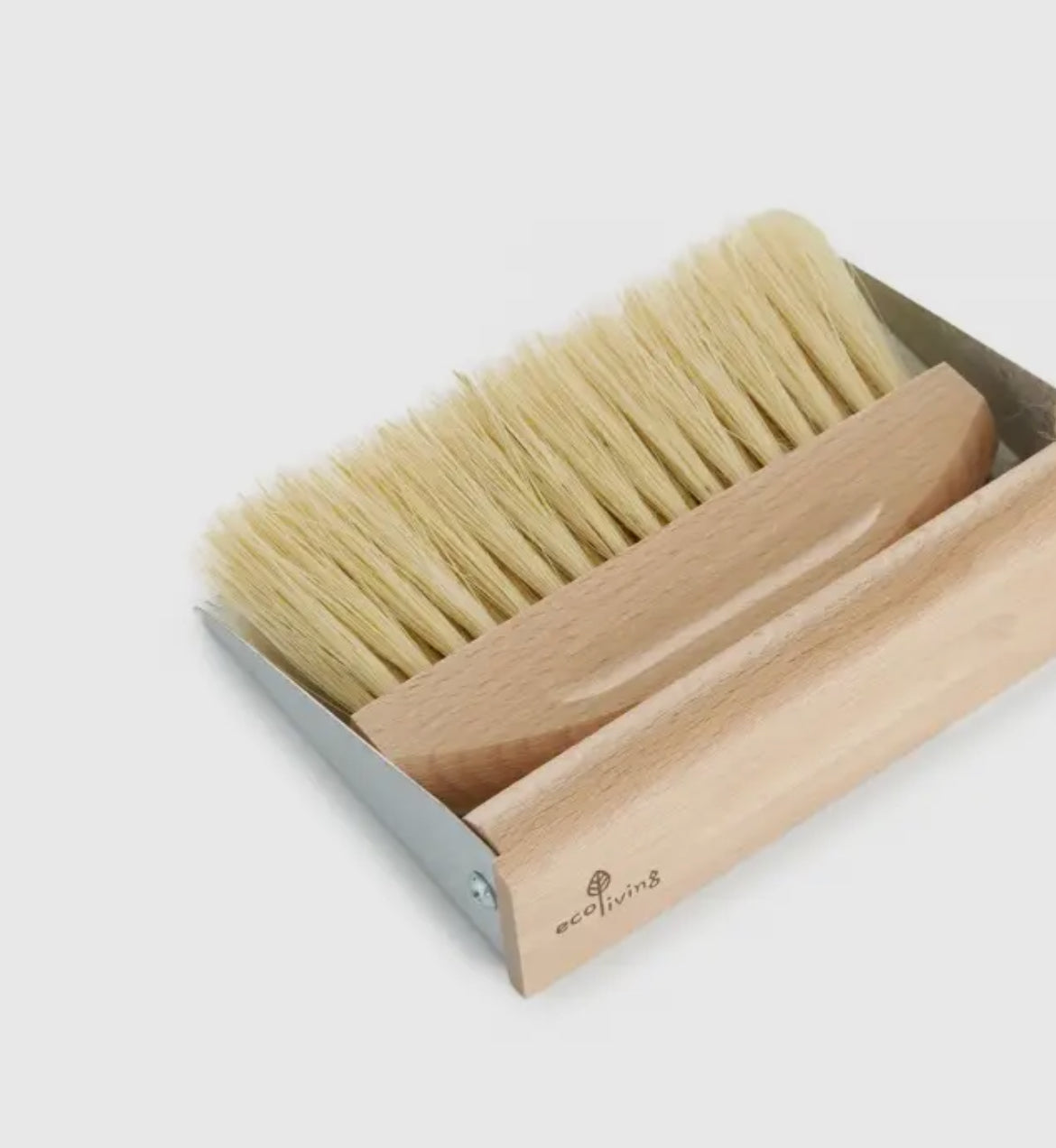 Cleaning brush with wooden handle and natural bristles in a box on a light gray background