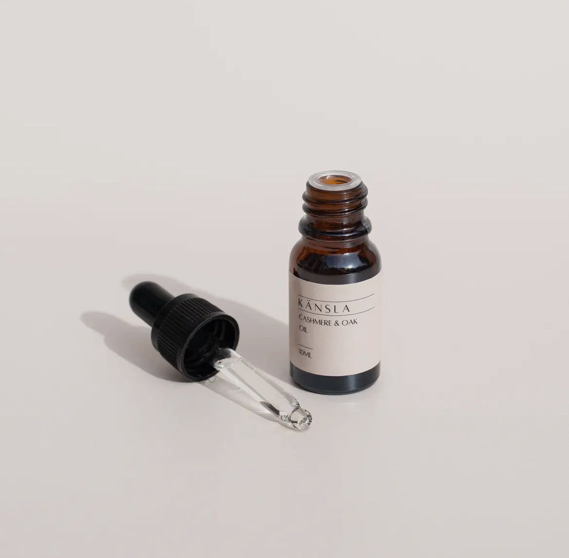 Brown glass dropper bottle with a white label on a light gray background