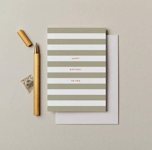 Striped birthday card with gold pen and seal on beige background