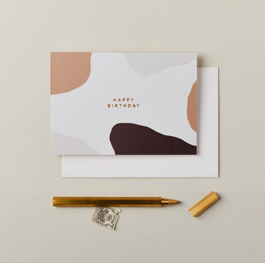 Greeting card with 'Happy Birthday' text, pen, and stamp on a beige background