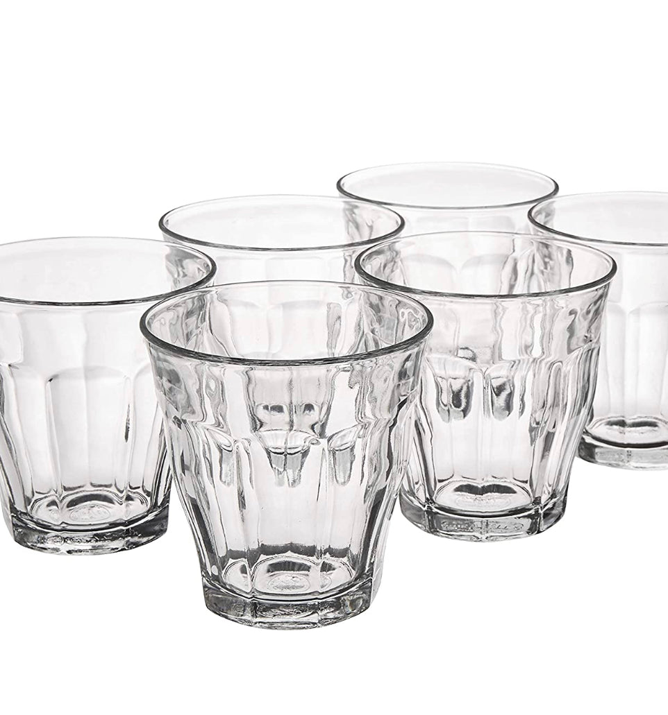 Set of six clear glass tumblers on a white background