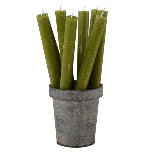 Set of green candles in a rustic metal pot on a white background