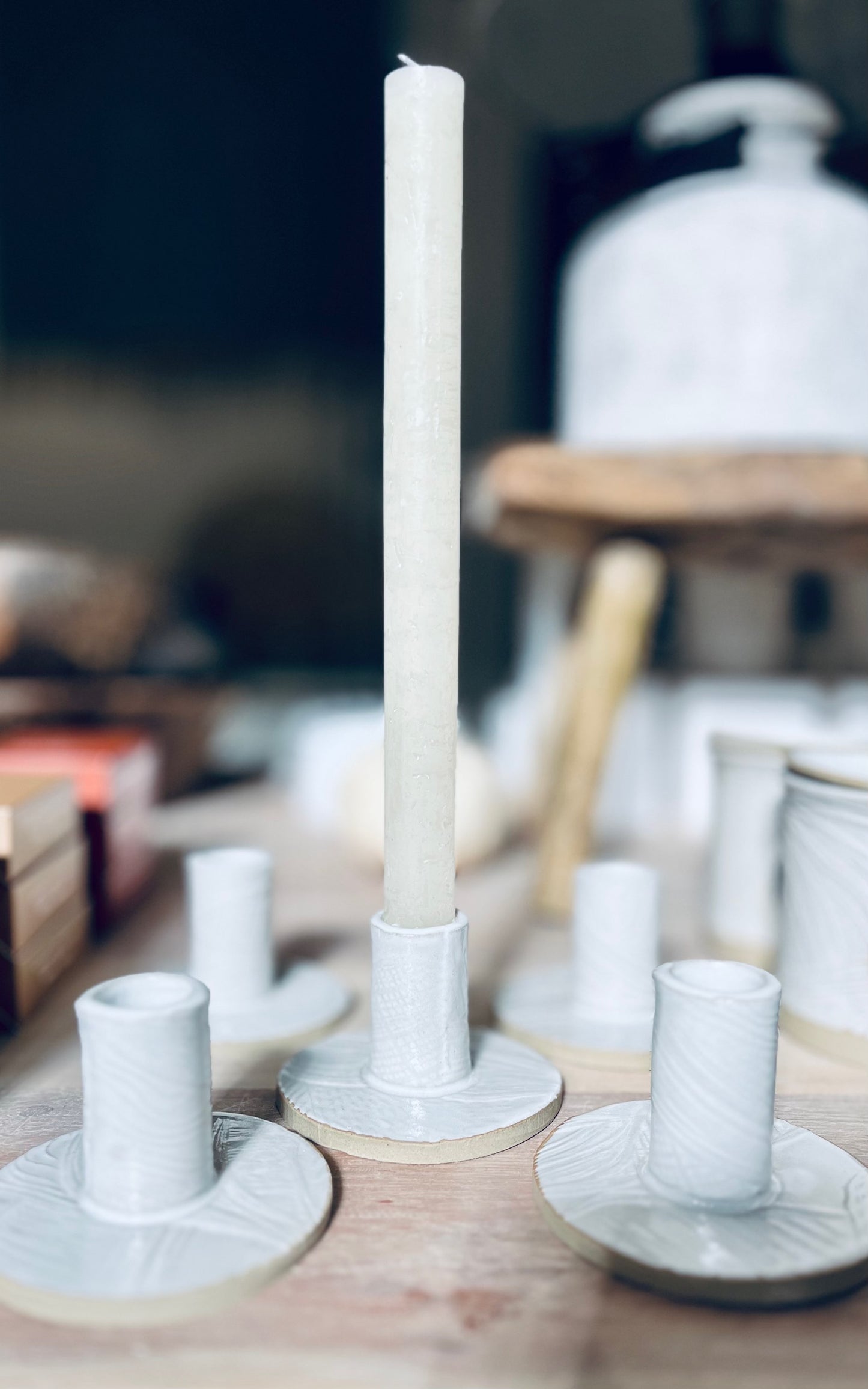 White candle on a decorative Stoneware Clay Candle Holder with blurred background