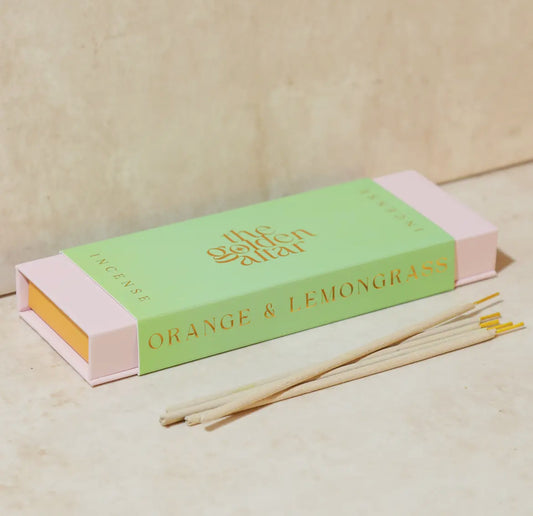 Incense sticks with a green and pink box labeled 'Orange & Lemongrass' on a beige background