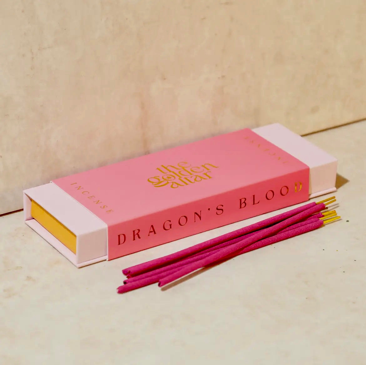 Pink incense box with 'Dragon's Blood' incense sticks on a beige background