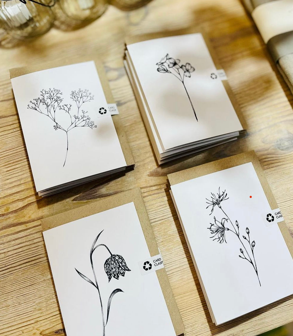 Set of greeting cards with floral designs on a wooden surface