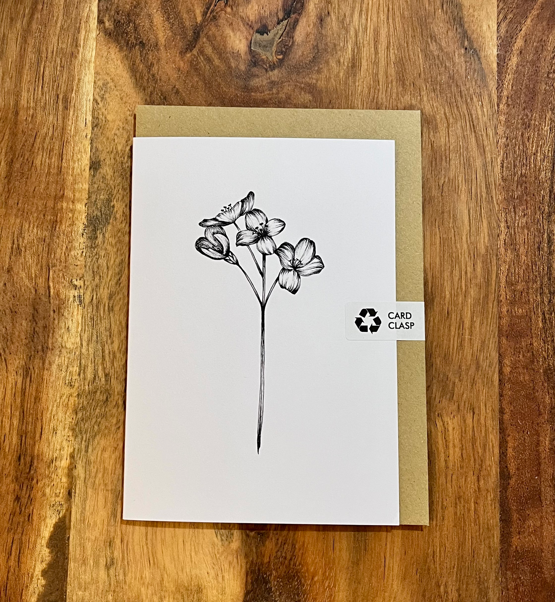 Greeting card with floral design on a wooden surface