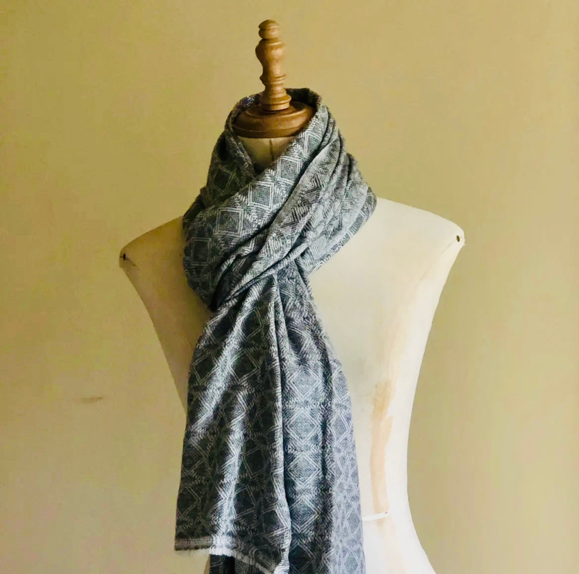 Scarf with geometric pattern on a mannequin against a plain background