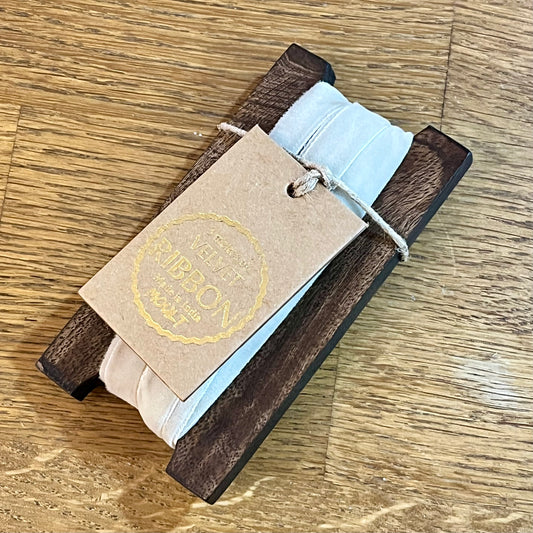 Wooden product with a light blue strap and a branded tag on a wooden surface